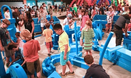 Math Fair floor, kids navigating big blocks as machinery.