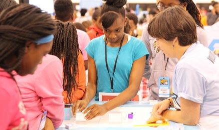 Math Fair floor, kids problem solving with objects on a table.